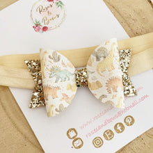Load image into Gallery viewer, Gold Dinosaur Leatherette and Glitter Bow Headband or Clip
